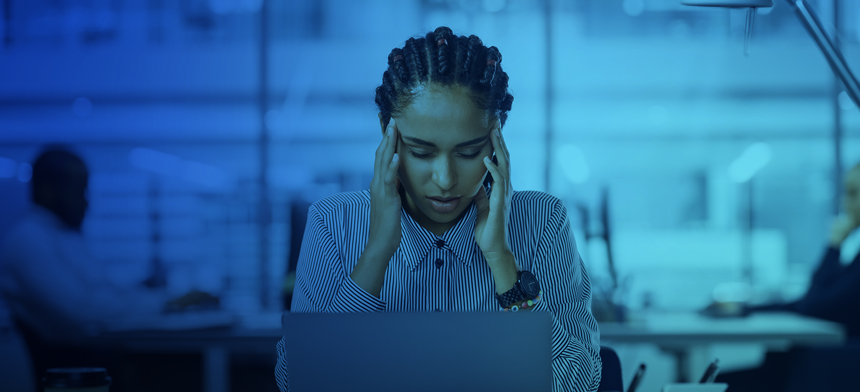 Woman sitting at desk feels stress during work and needs mental health support