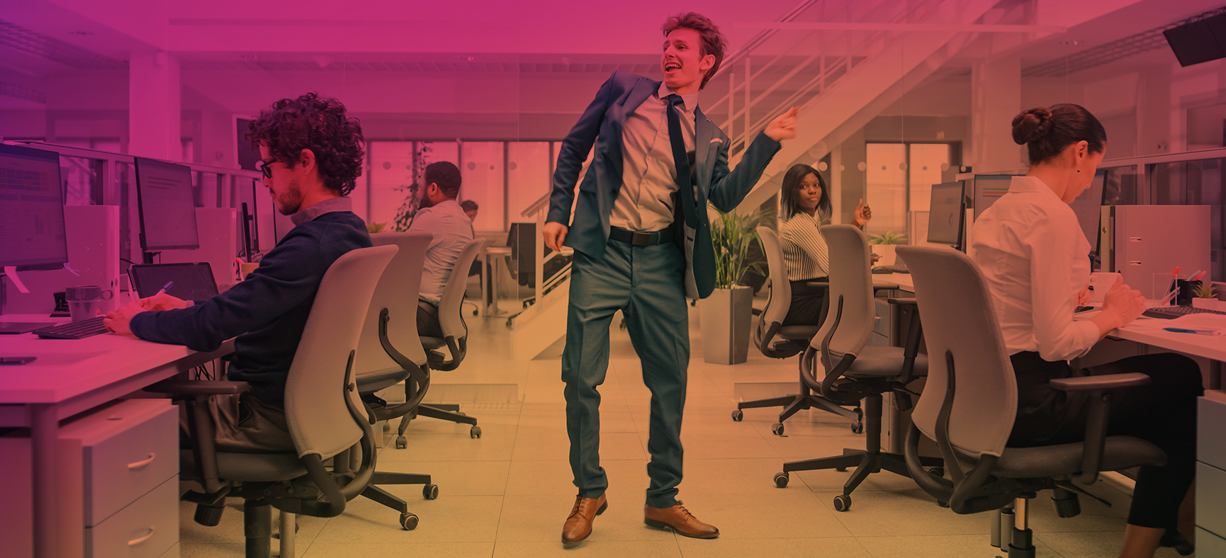 Man dances in an office setting, clearly communicating in a different tone than his fellow small business employees