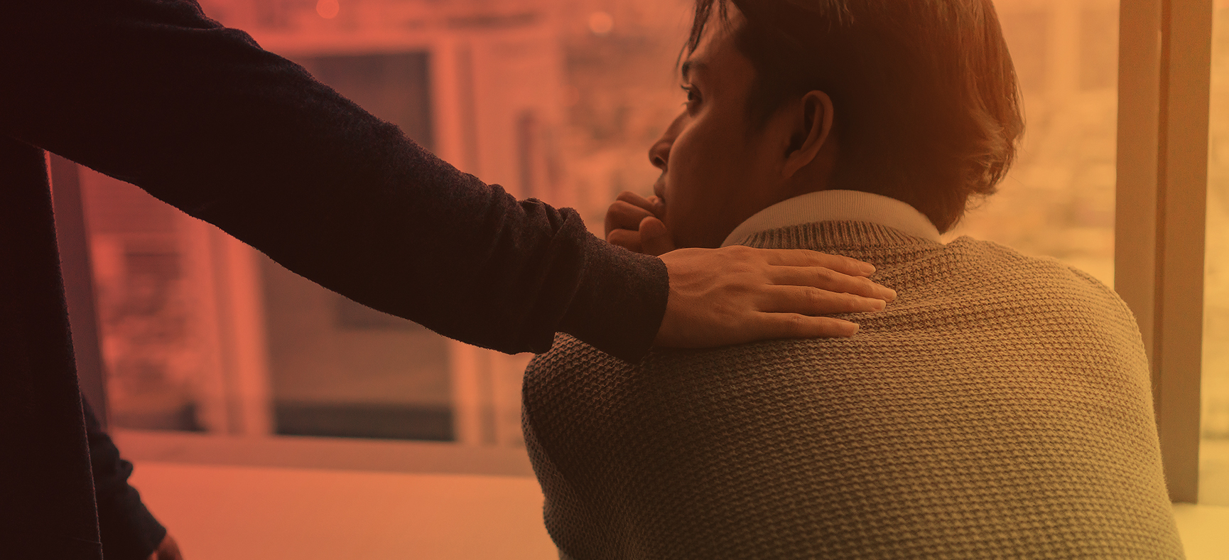 Woman rests her hand on the shoulder of a colleague who is experiencing a mental health crisis