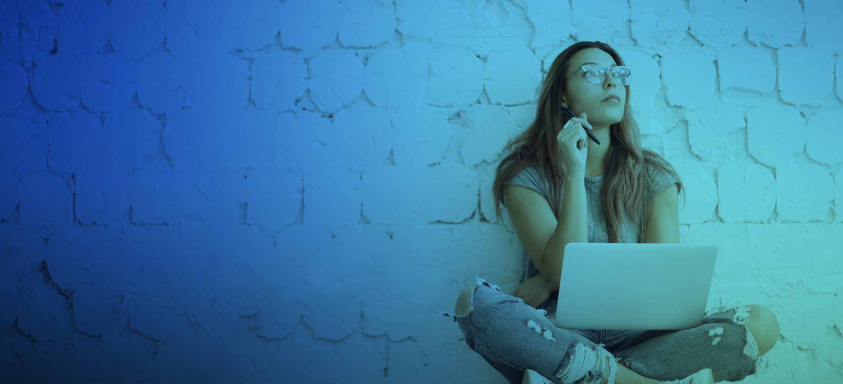 Woman sits with her laptop and ponders how to write an ebook