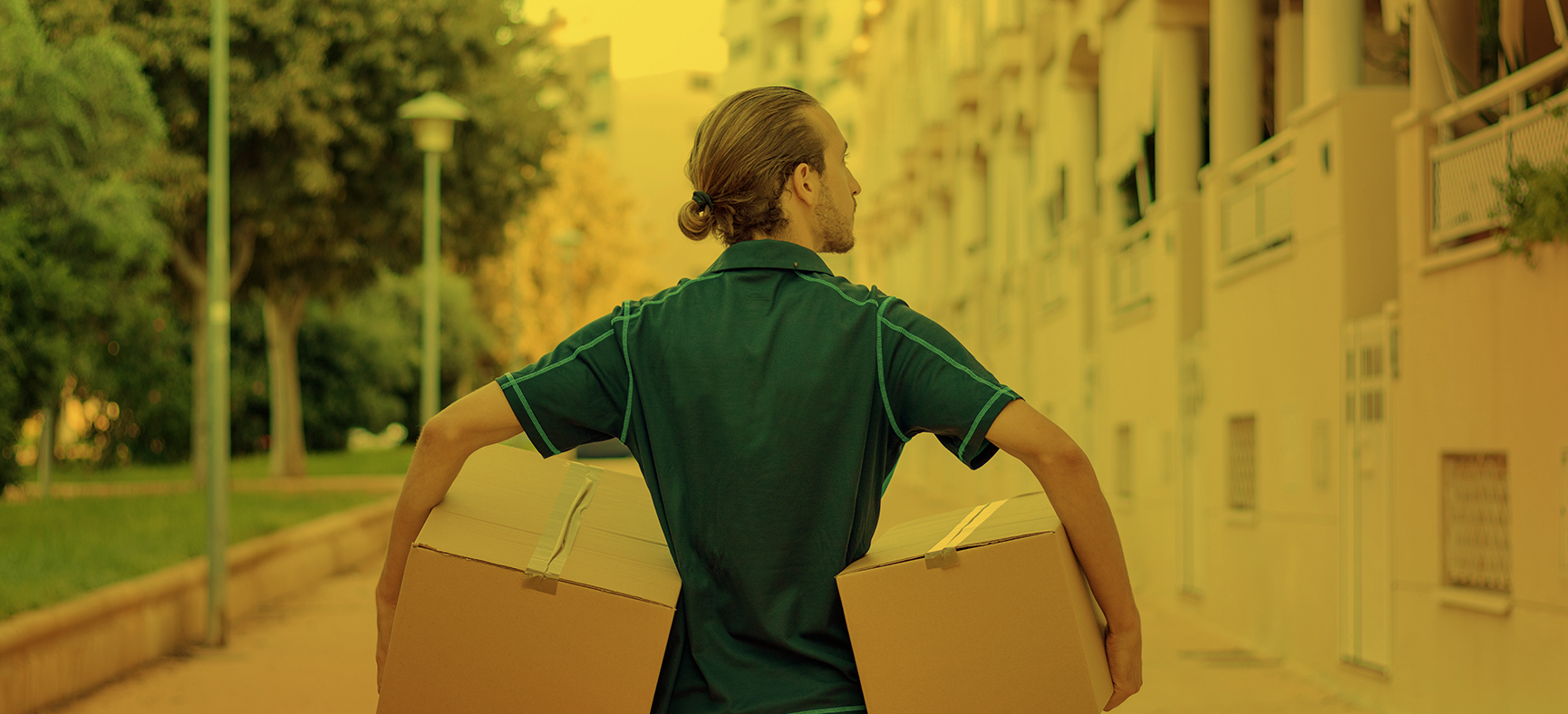 Amazon deliveryman carries boxes to residential neighborhood.