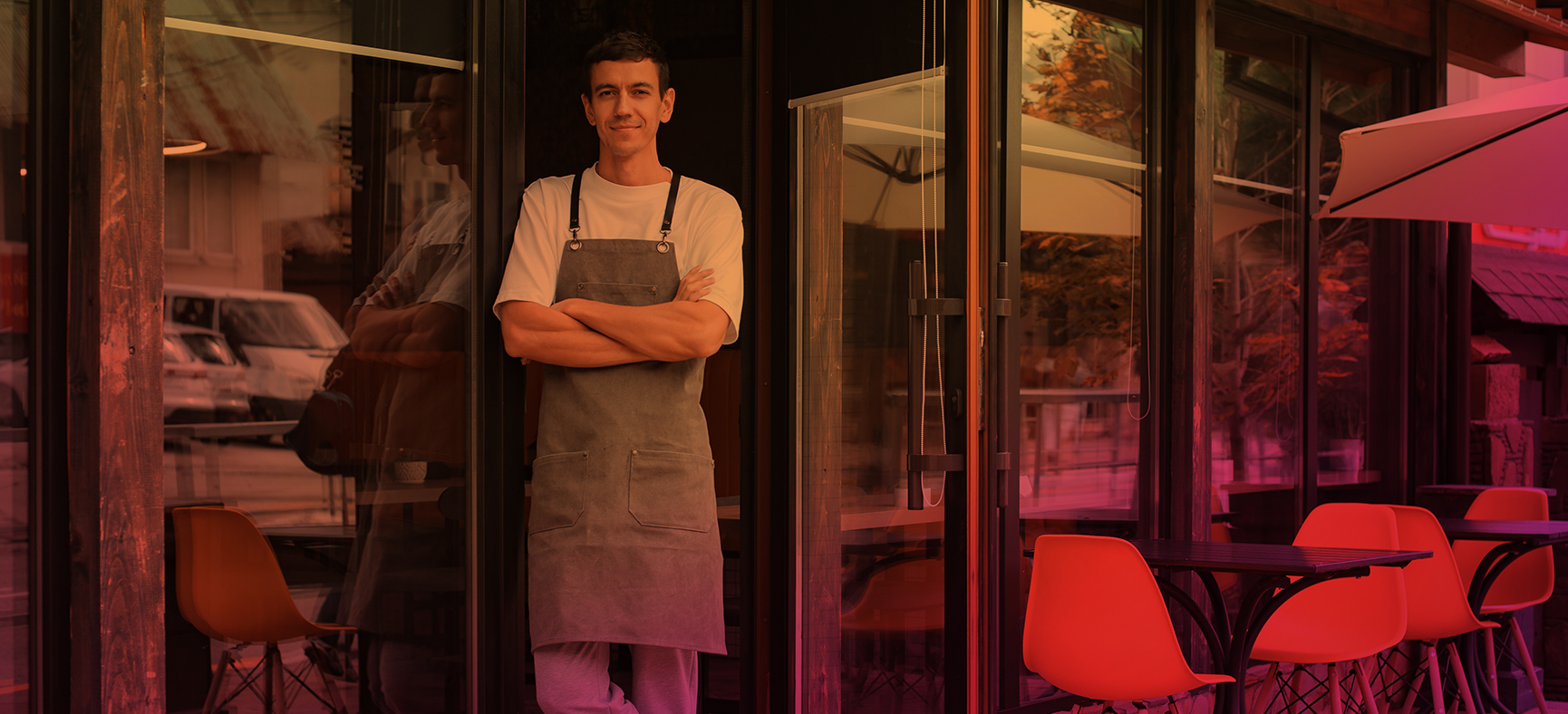 Man who owns a coffee shop stands in the front entrance as he contemplates how to stand out from the competition.