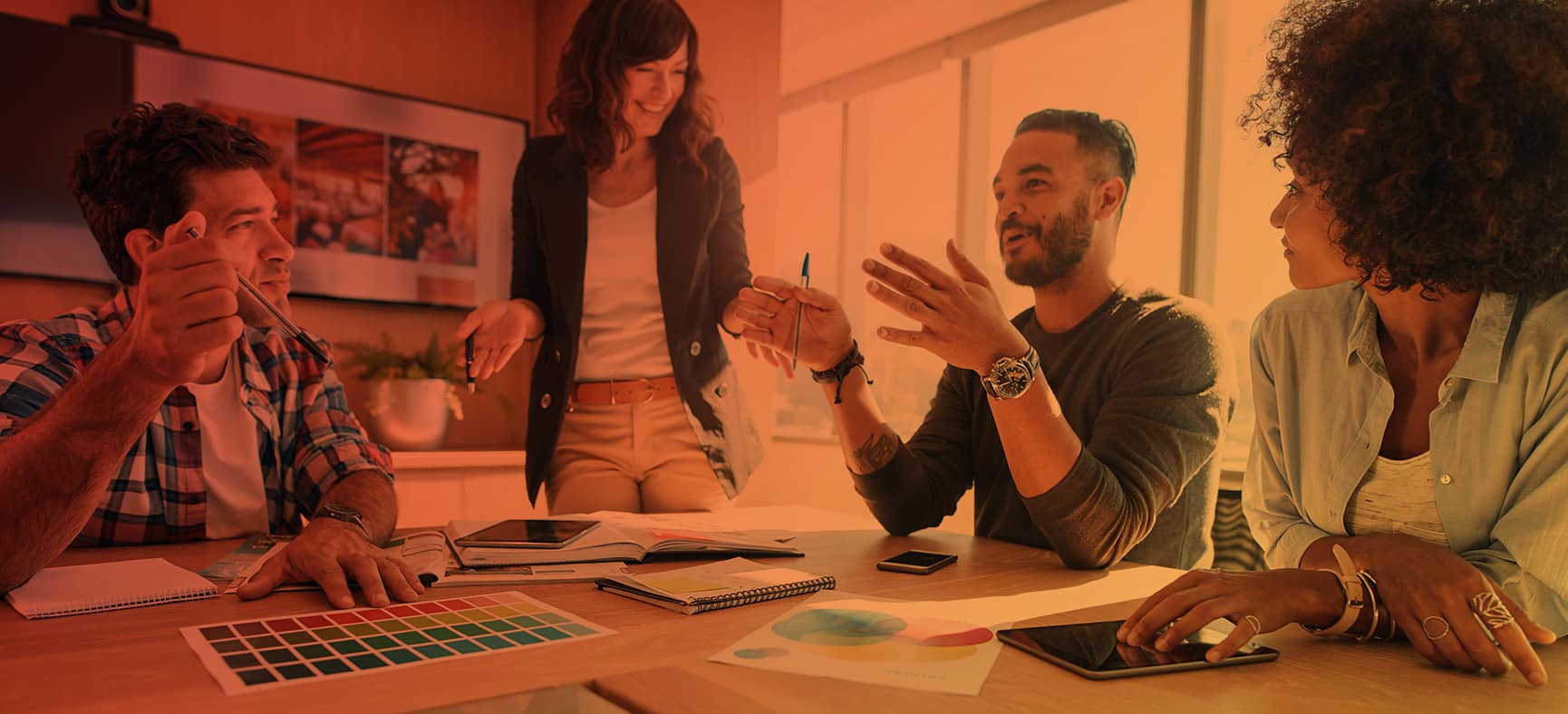 Marketing team gathers around a table to discuss a brand makeover