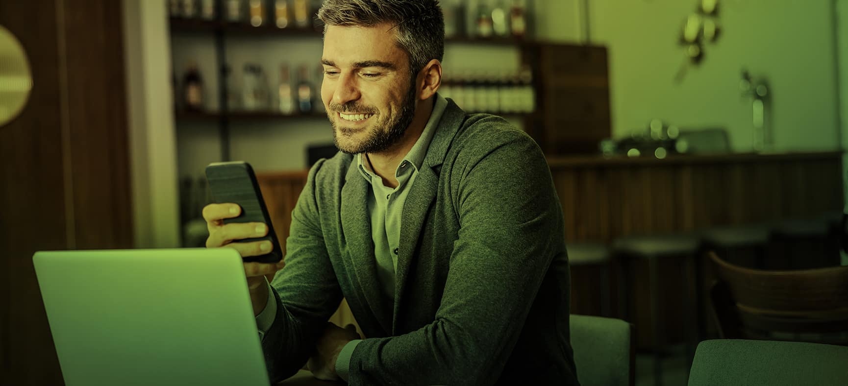 A man works on both his laptop and his phone, enjoying the benefits of responsive website design