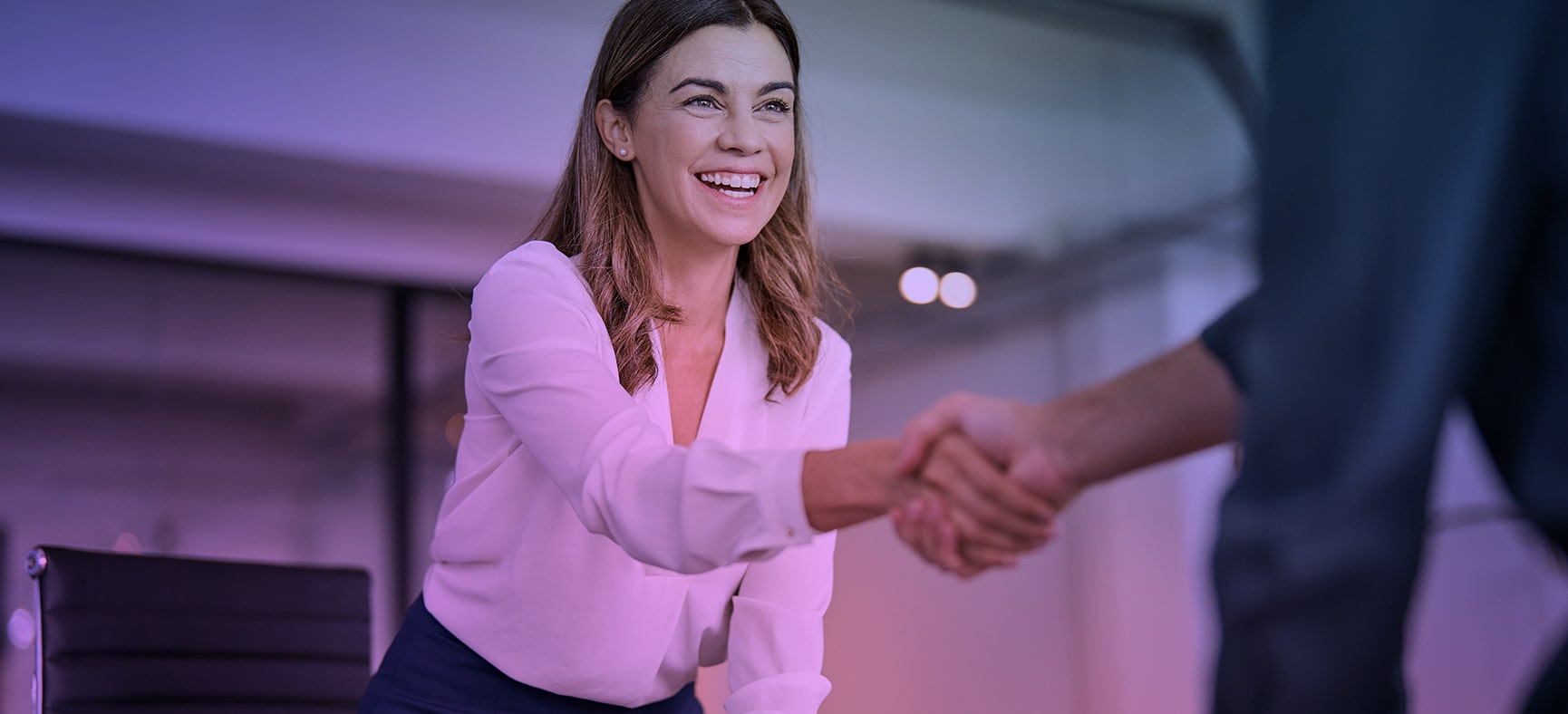 Businesswoman implements new HR strategies and shakes the hand of a new hire